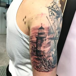 Tatouage bras petite phare et rose des vents 